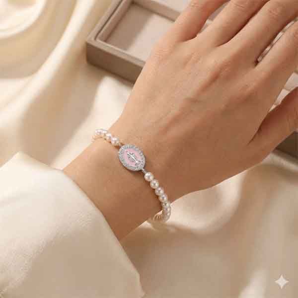 Pulsera de perlas con medalla Milagrosa en plata y esmalte rosa colocada en muñeca