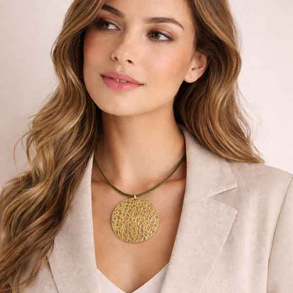 Modelo luciendo el Collar Sahara chapado en oro con medallón calado dorado