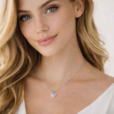 Collar de corazón pequeño en plata con circonitas blancas llevado por una modelo, diseño delicado y elegante