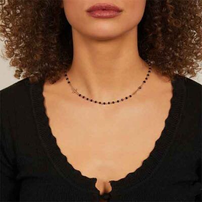 Collar rosario dorado con cristal negro llevado por modelo