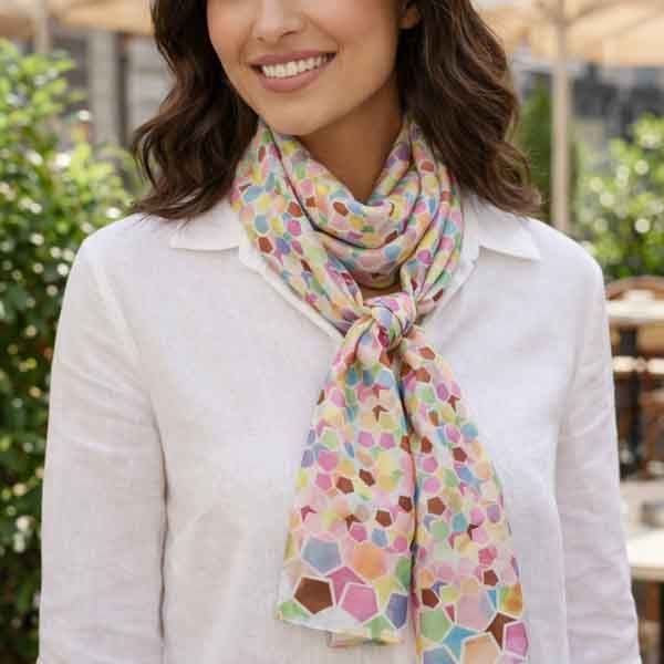 Foulard de seda estampado multicolor con nudo delantero, llevado por modelo con camisa blanca.