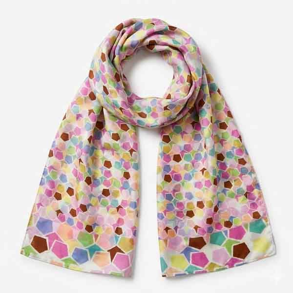 Foulard de seda estampado multicolor con formas geométricas en tonos rosa, verde, azul y mostaza sobre fondo claro
