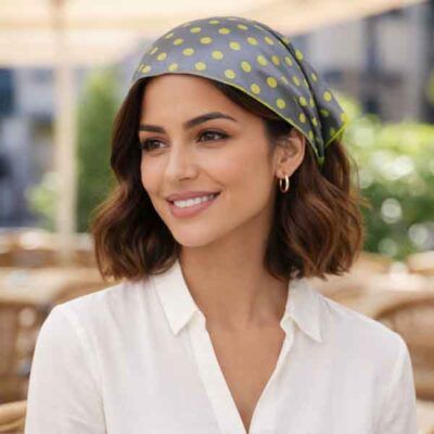 Pañuelo de lunares gris y verde colocado en la cabeza tipo bandana