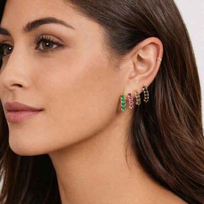Modelo con pendientes Tennis Color dorados de AMEN con circonitas verde, fucsia y negras