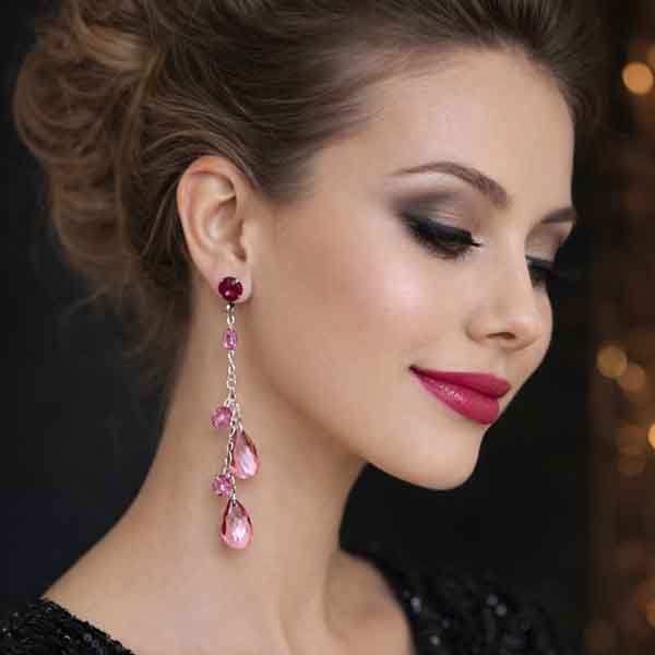Pendientes largos rosa y fucsia con lágrimas de cristal en modelo de fiesta maquillada