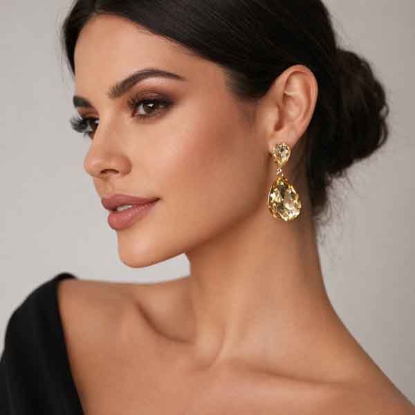 Modelo con pendientes lágrima cristal champán dorado para invitada de boda