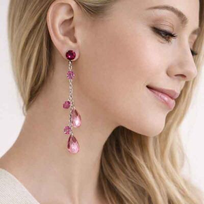 Pendientes largos rosa y fucsia con lágrimas de cristal en modelo de fiesta maquillada