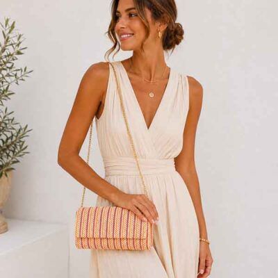 Modelo con bolso clutch Capri Apricot multicolor y cadena dorada