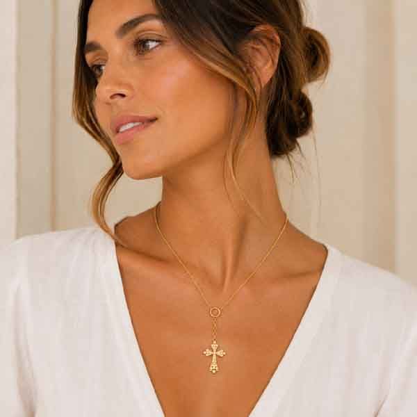 Modelo luciendo collar Diro de Luxenter con cruz y perlas acabado en oro amarillo de 18k