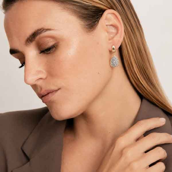 Modelo luciendo los Pendientes Sirian de Luxenter con circonitas brillantes y acabado en oro amarillo